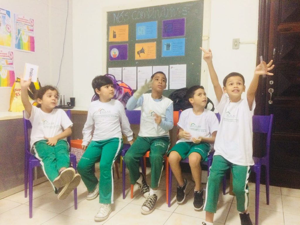 Kids raising hands in classroom