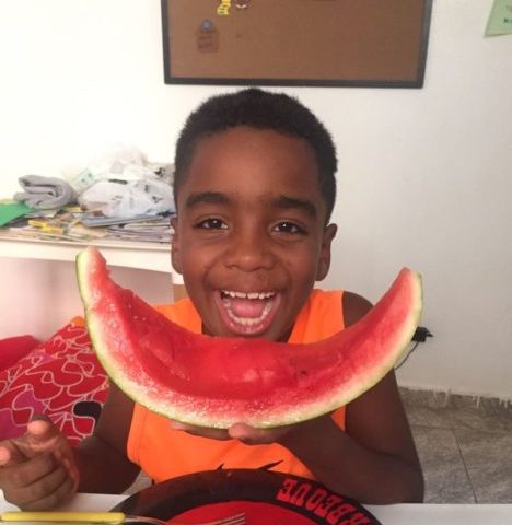 Boy eating healthy food at NGO in favela in Rio de Janeiro