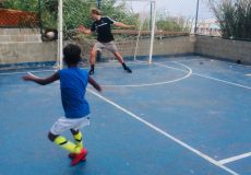 EduMais football volunteer Mads goes in goal while one of the students tries to score against him