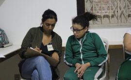 EduMais volunteer English teacher Demi helps out a student with her work in the classroom