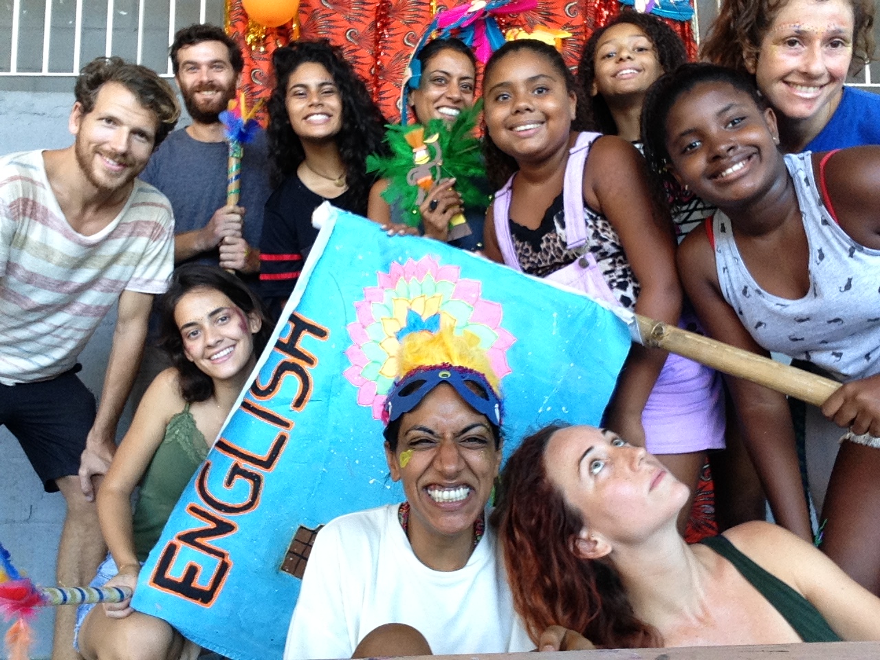 Participants on EduMais's 2018 Summer Camp and their volunteer English teachers hold a flag saying English on it