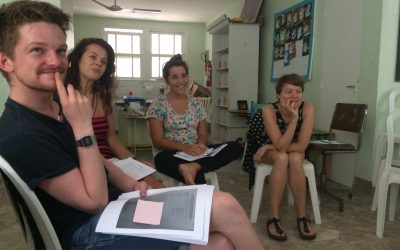 EduMais volunteers sat in a semi-circle while being trained in Positive Discipline