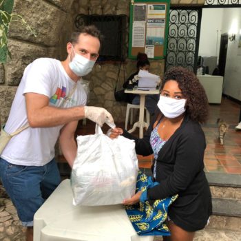 EduMais volunteer hands out food baskets