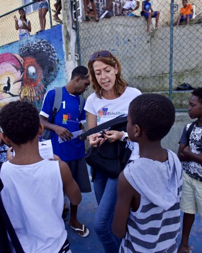 EduMais founder Diana Nijboer and William give out rucksacks donated by WINGS foundation