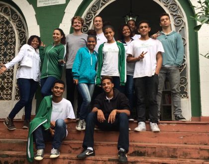 EduMais volunteer English teacher Dominic with a group of students in front of Solar Meninos de Luz school