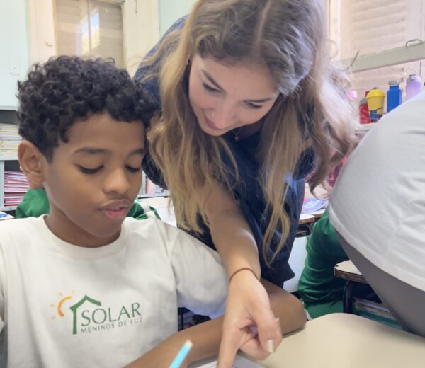 Teacher helps student Woman and child. Woman points something out on paper