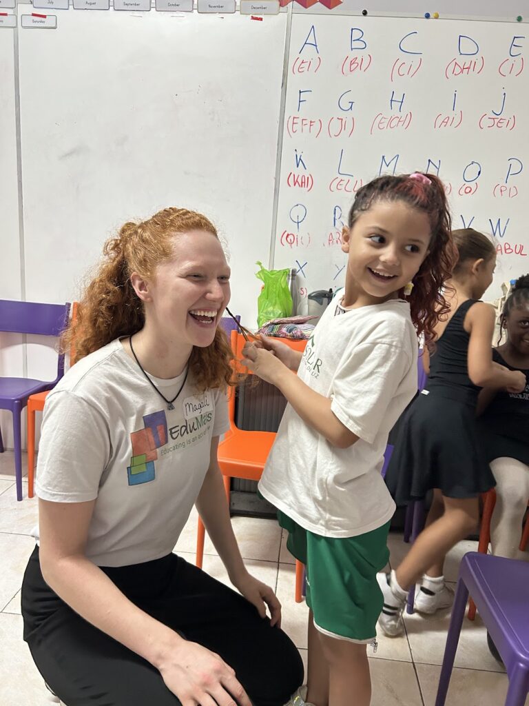 Magali - Home Page Love woman and kid in classroom. Kids braiding the hair of woman