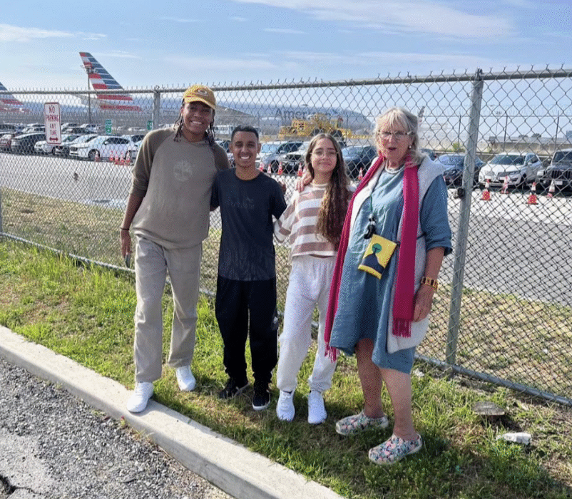 two young men and two women. In the background an airplane.