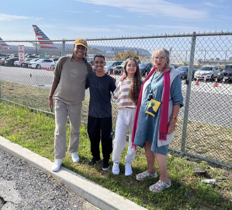 two young men and two women. In the background an airplane.