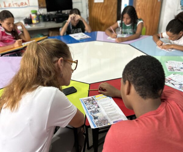 IMG_7761 Een vrijwilliger zit tijdens een les van EduMais met leerlingen aan een tafel